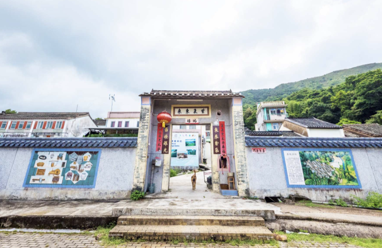 鄉村入口牌坊，兩側圍牆繪有壁畫