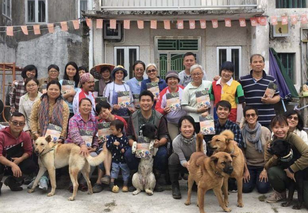 村民與參加者連同狗隻在村屋前合照